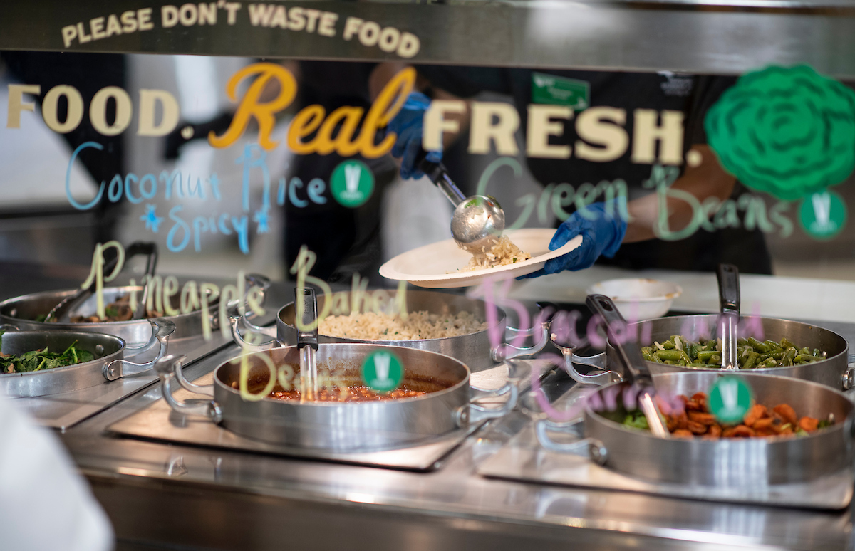 Image of hot food line at Bruce Hall, with blurry text that is on the sneeze guard window