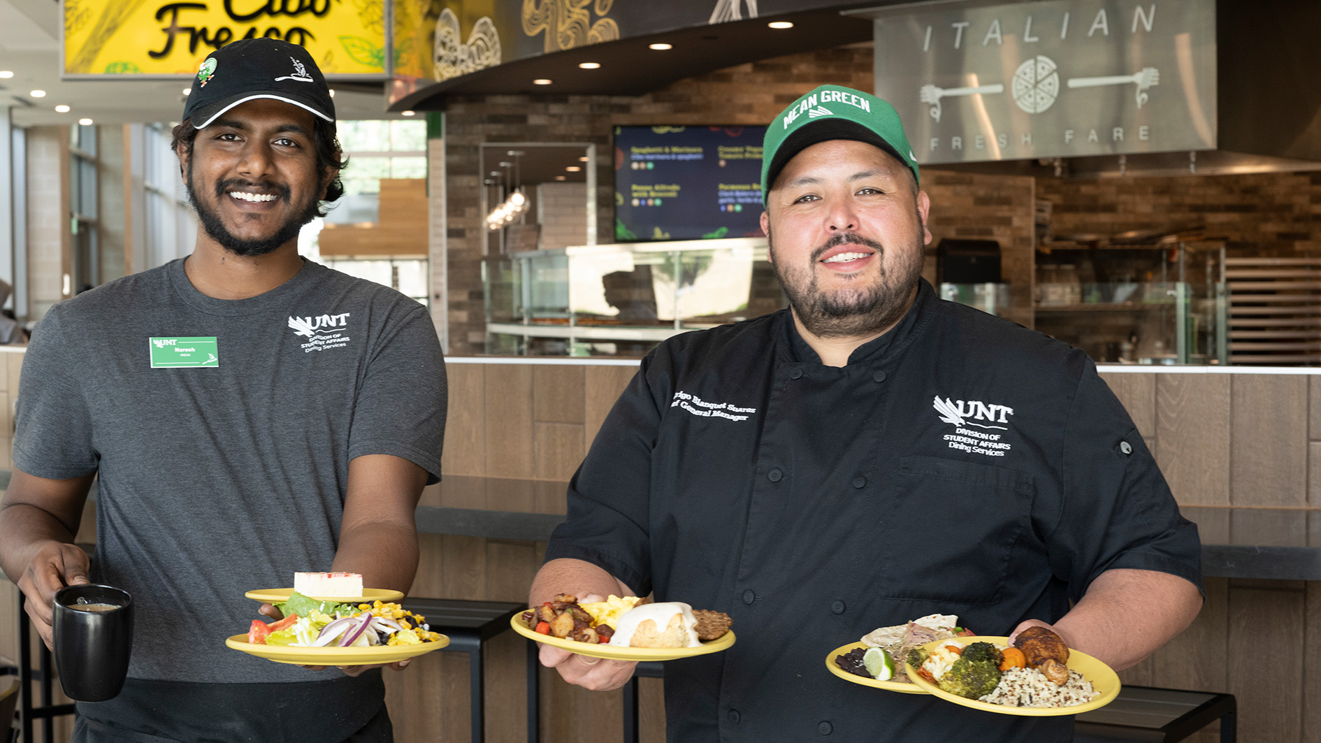 Chef and assistant holding plates of cooked food and welding visitors to Eagle Landing. 